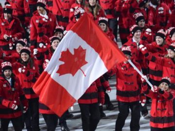 Canada's flag bearer, ice hockey player Hayley Wickenheiser leads her national delegation during the Opening Ceremony of the Sochi Winter Olympics at the Fisht Olympic Stadium on February 7, 2014 in Sochi. AFP PHOTO / JONATHAN NACKSTRAND        (Photo credit should read JONATHAN NACKSTRAND/AFP/Getty Images)